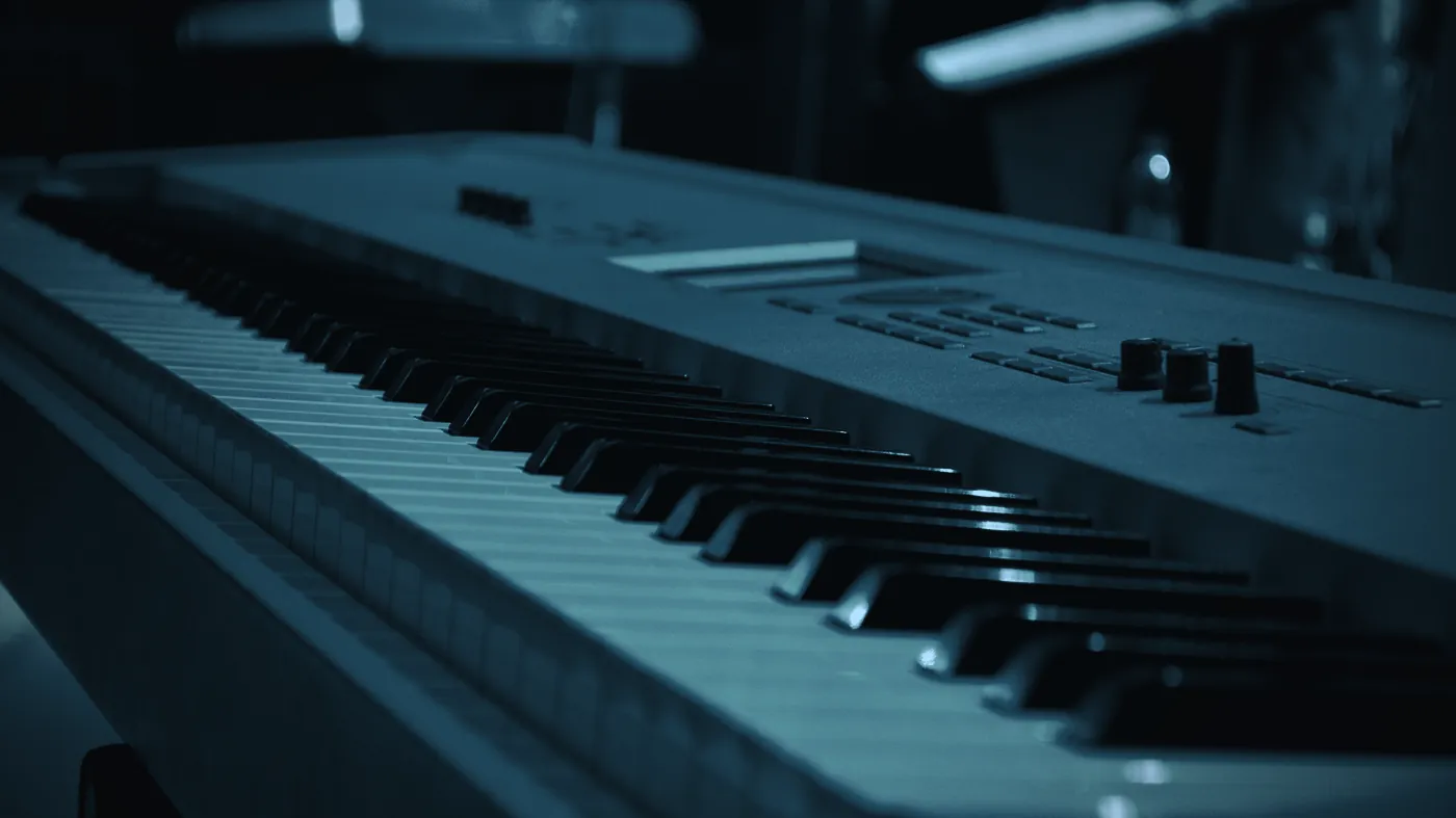 A stage keyboard under coloured light